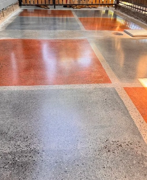 Hormigón teñido en exterior residencial con tintes rojo y gris GemTone